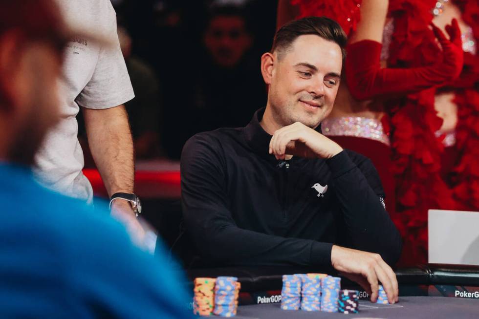 Toby Lewis smiles as he grabs a stack of his poker chips during the $10,000 buy-in No-limit Hol ...