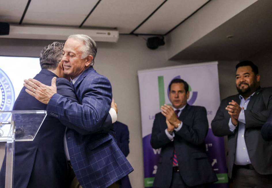 Peter Guzman, president of the Latin Chamber of Commerce, left, hugs Gov. Joe Lombardo, right, ...