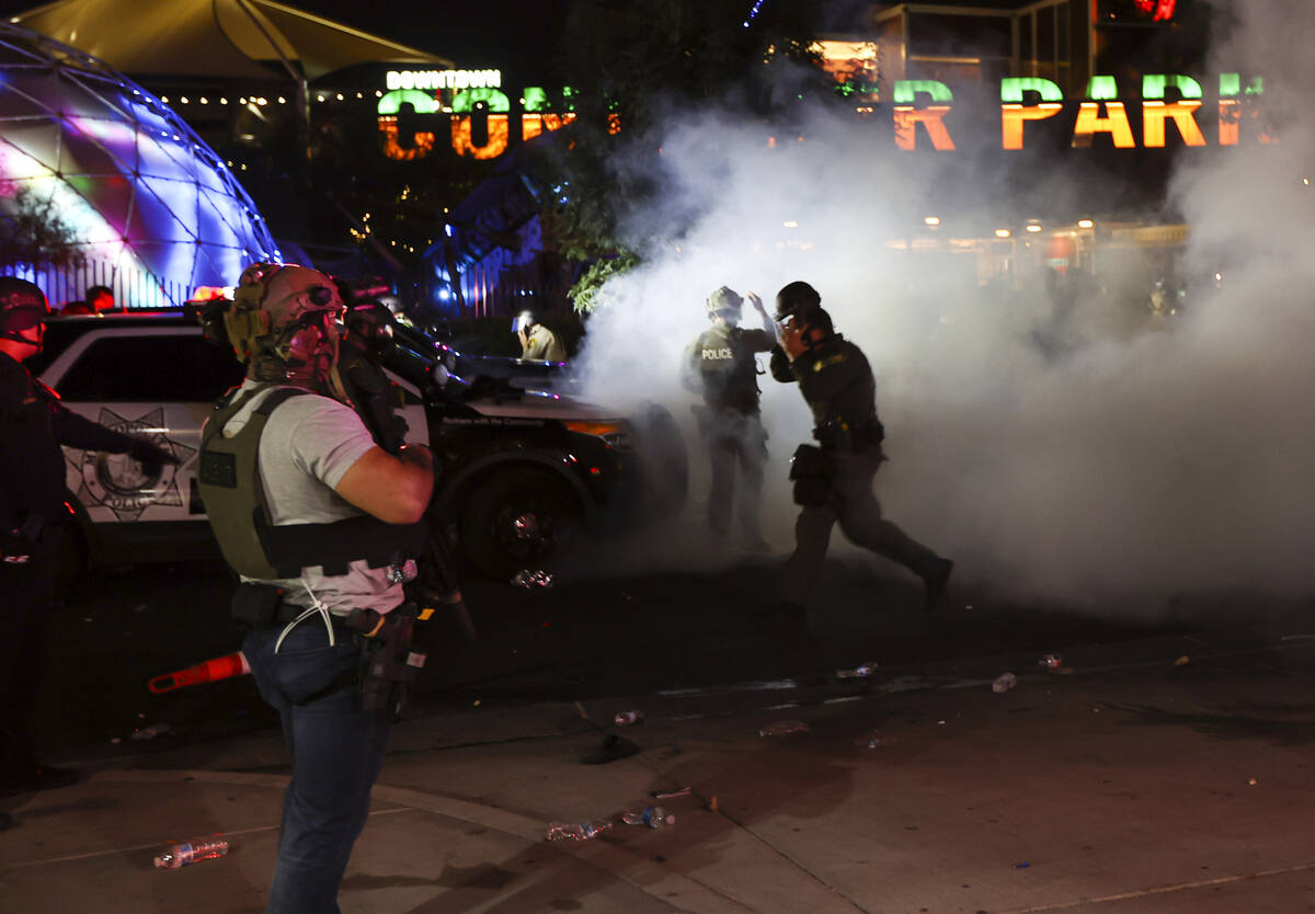 A man who appears to be impersonating a federal agent, left, stands among Las Vegas police offi ...