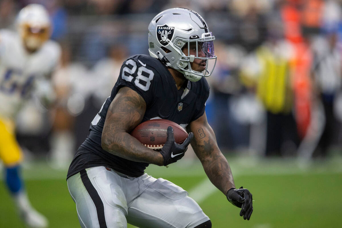 Raiders running back Josh Jacobs (28) looks for room to run during the first half of an NFL gam ...
