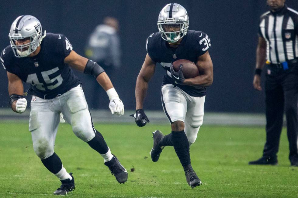 Raiders running back Zamir White (35) follows Raiders fullback Jakob Johnson (45) on a run agai ...