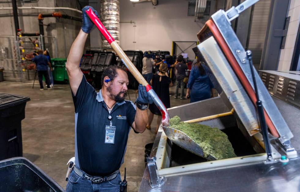 Allegiant Stadium team member Luis Garcia loads grass clippings into their composter which cont ...