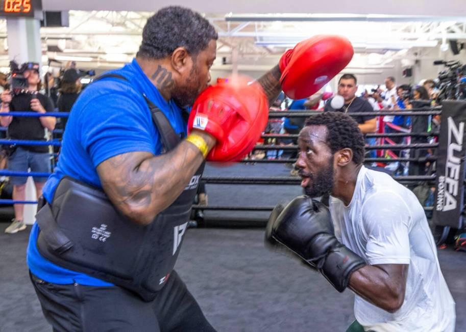 Terence Crawford ducks below the pads held by trainer Red Spike at the UFC Apex gym on Wednesda ...