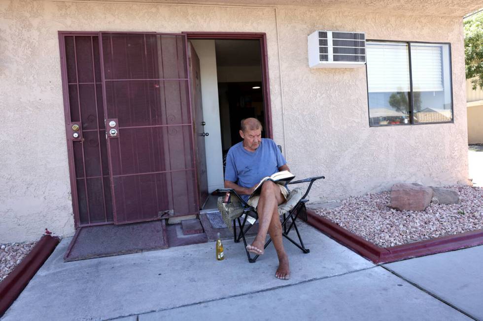 A person who declined to give their name reads in cool weather on East Stewart Avenue in downto ...