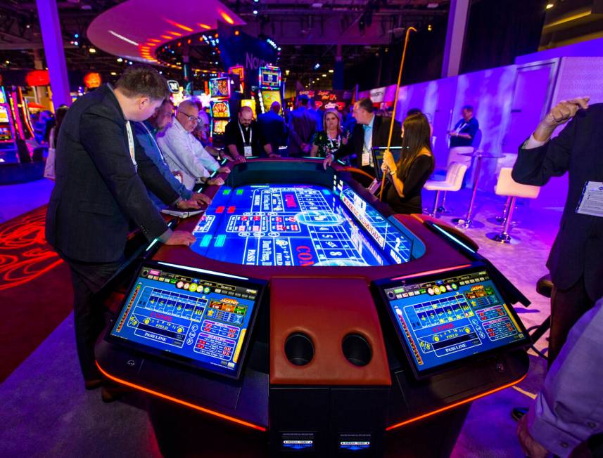 Attendees play on a new digital craps table from Aruze Gaming during the 2019 Global Gaming Exp ...