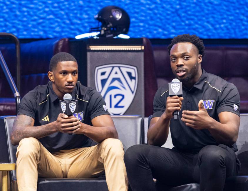 Washington Huskies quarterback Michael Penix Jr., left, listens as linebacker Edefuan Ulofoshio ...