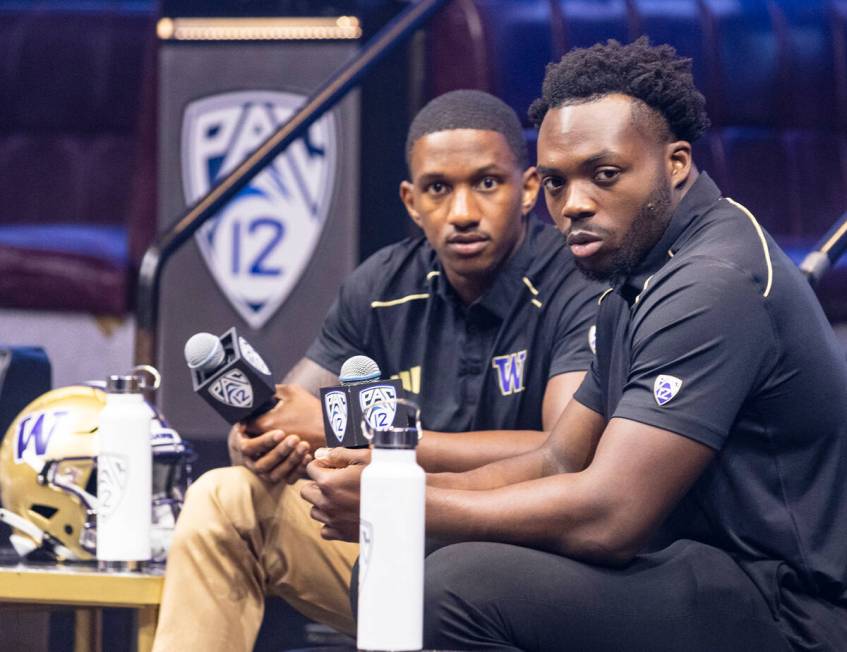 Washington Huskies quarterback Michael Penix Jr., left, and linebacker Edefuan Ulofoshio listen ...