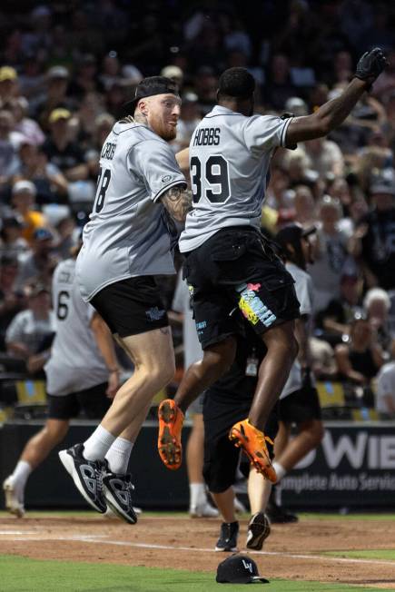 Raiders defensive end Maxx Crosby, left, and cornerback Nate Hobbs celebrate after Hobbs scored ...