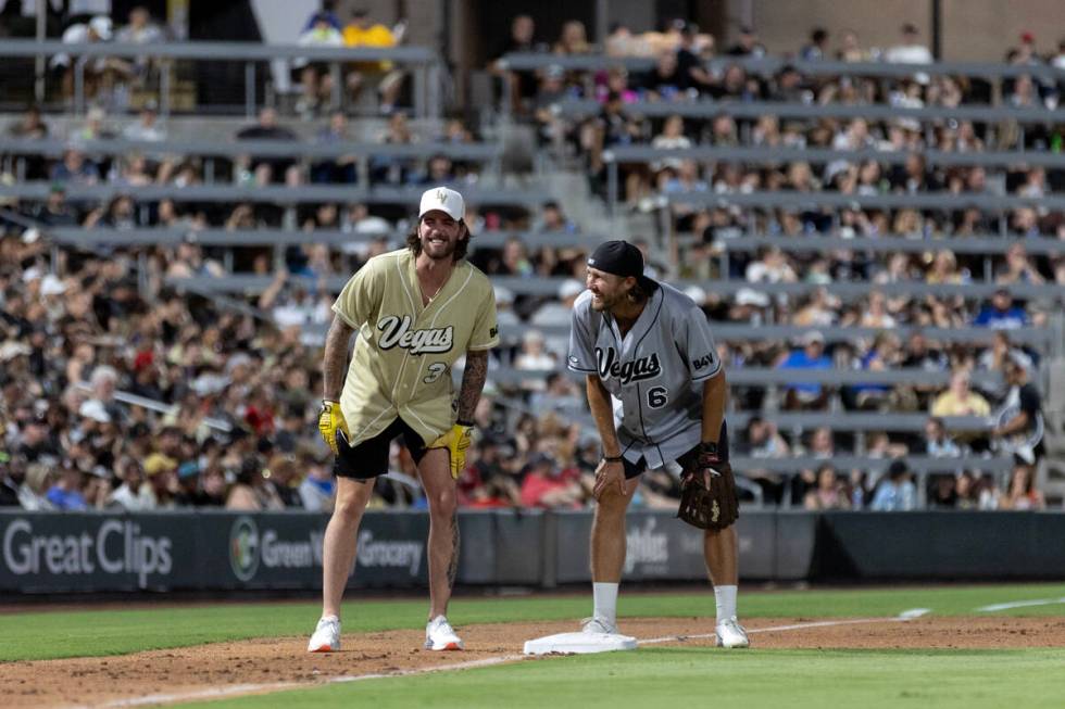 Golden Knights goaltender Logan Thompson and Raiders punter A.J. Cole III laugh at third base d ...