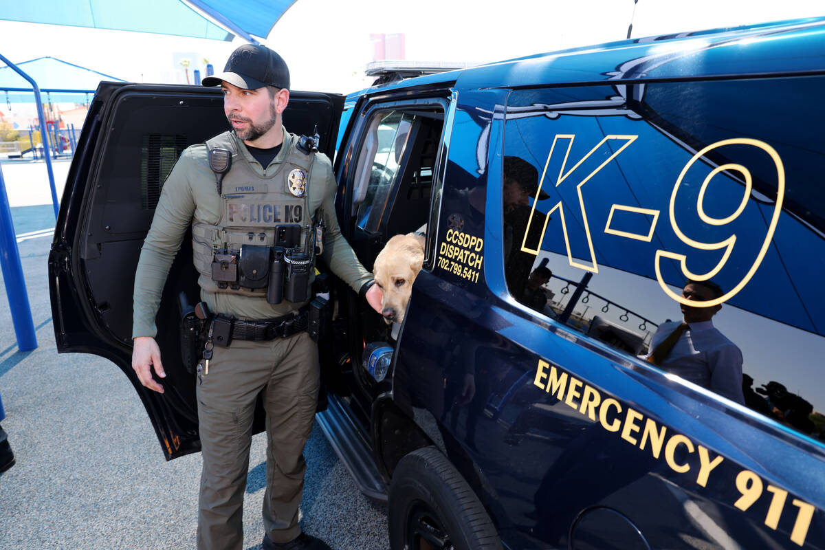 Clark County School District K-9 Officer Joseph Thomas talks to a reporter while holding K-9 Ki ...