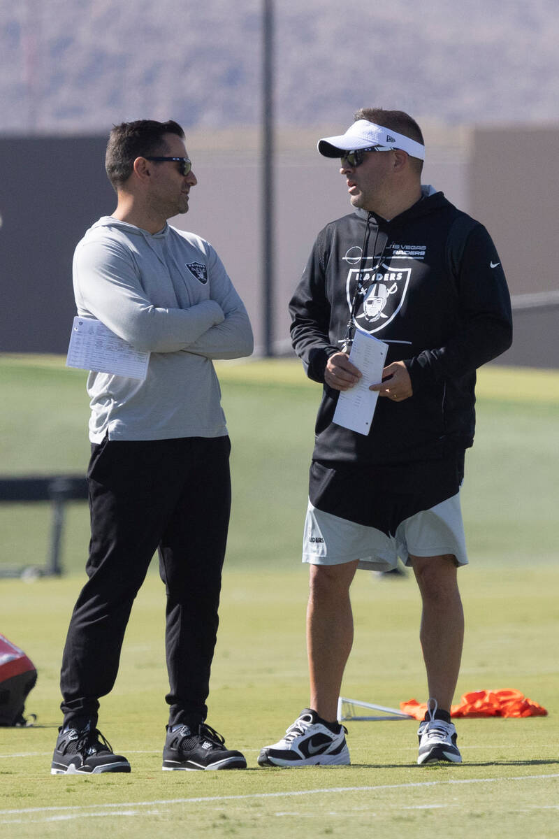 Raiders general manager Dave Ziegler, left, and head coach Josh McDaniels meet during practice ...