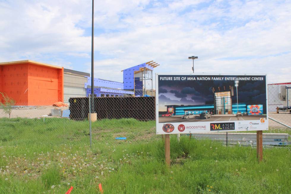 A sign shows a rendering of an under-construction entertainment center in New Town, North Dakot ...