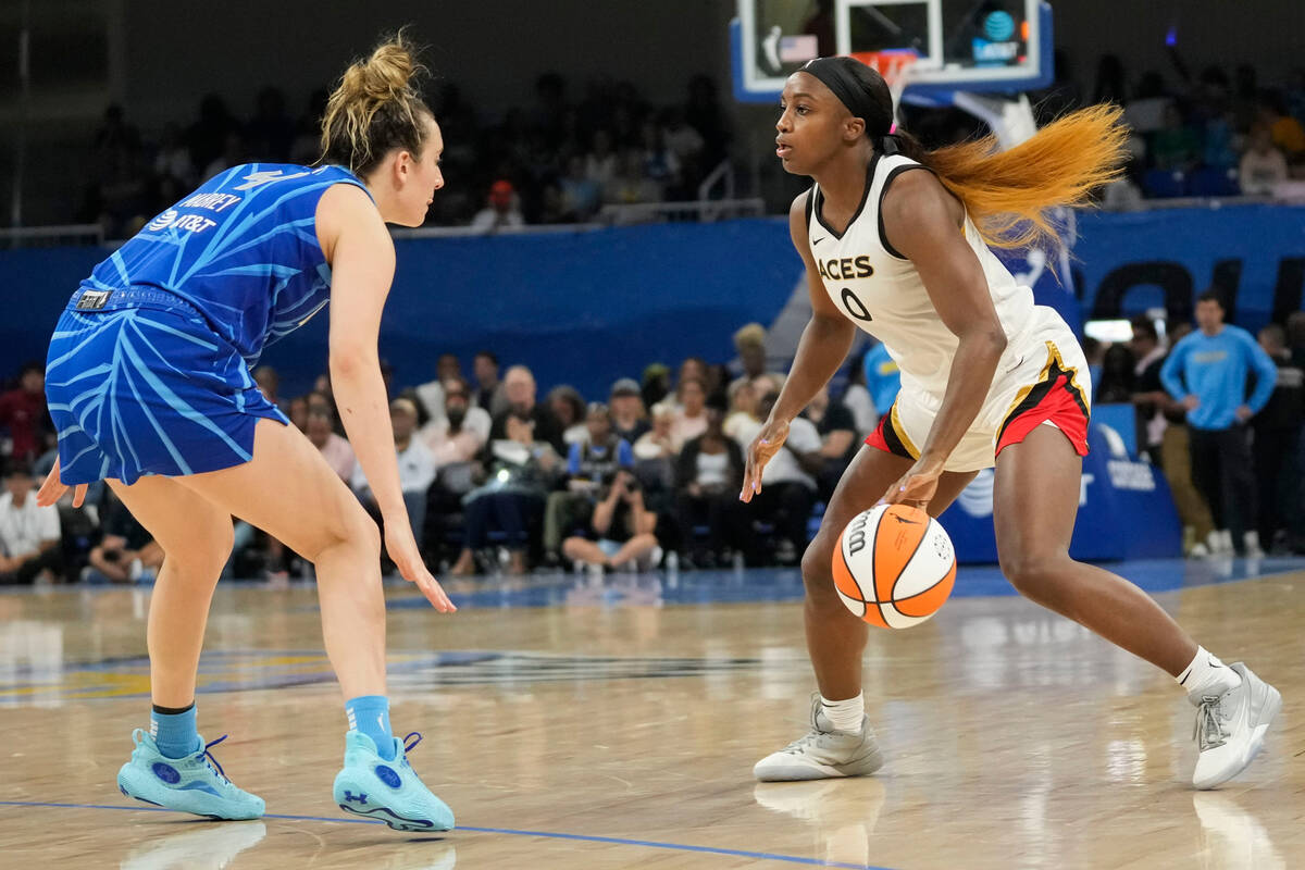 Las Vegas Aces guard Jackie Young is defended by Chicago Sky guard Marina Mabrey, left, during ...