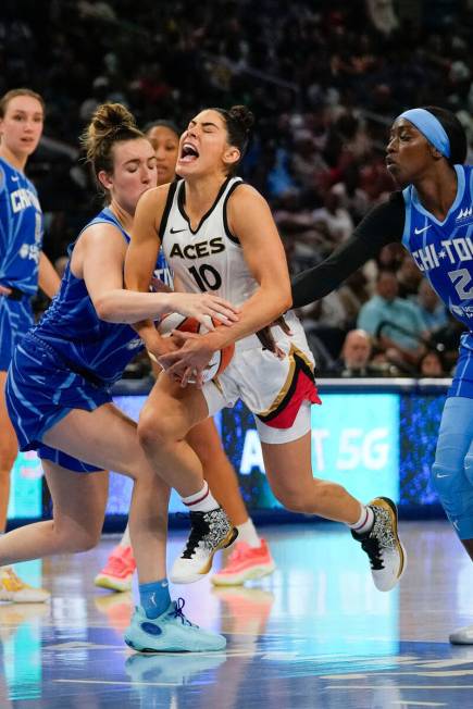 Las Vegas Aces guard Kelsey Plum, center, drives between Chicago Sky guard Marina Mabrey, left, ...