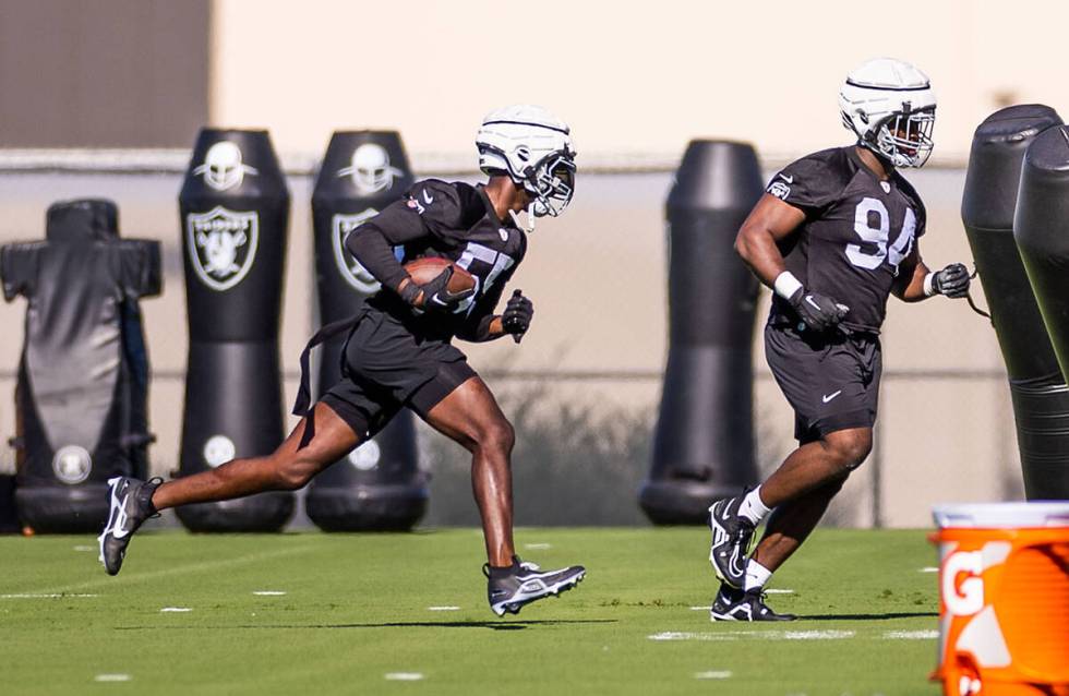 Raiders DE Chandler Jones (55) runs back a fumble as DT Matthew Butler (94) blocks for him duri ...