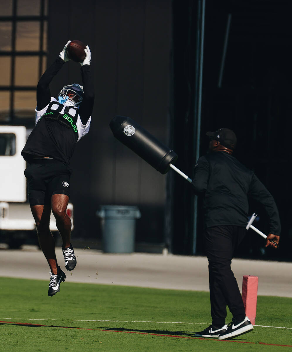 Raiders wide receiver Tre Tucker leaps into the air to catch a ball during a drill at training ...