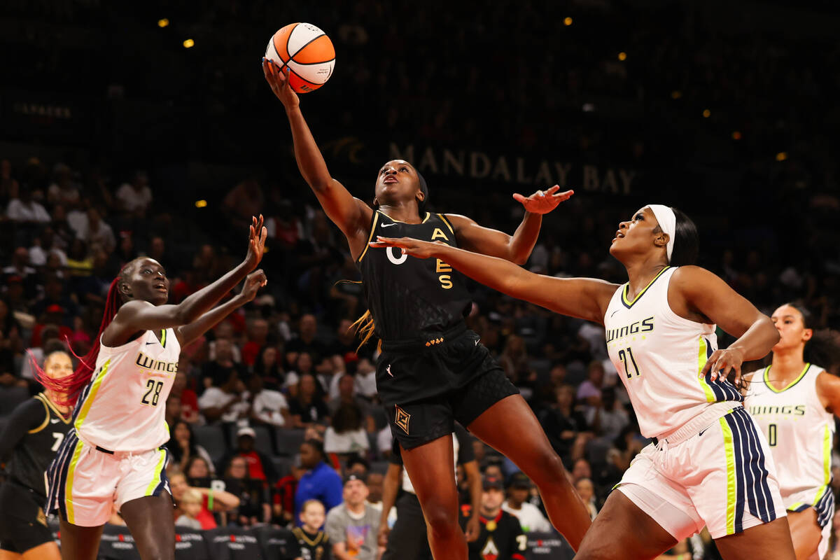 Las Vegas Aces guard Jackie Young (0) shoots a layup around Dallas Wings center Kalani Brown (2 ...