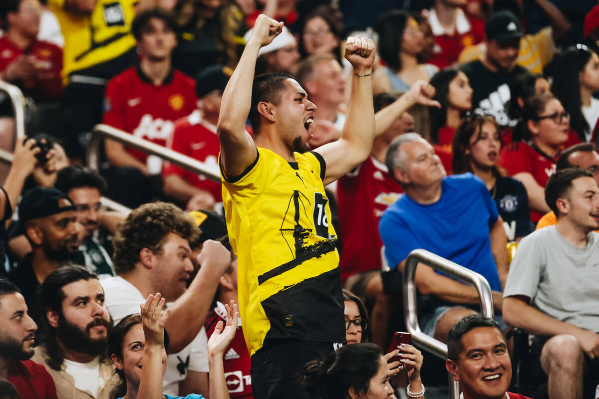 A Borussia Dortmund fan cheers as his team scores a goal during a match up against Manchester U ...