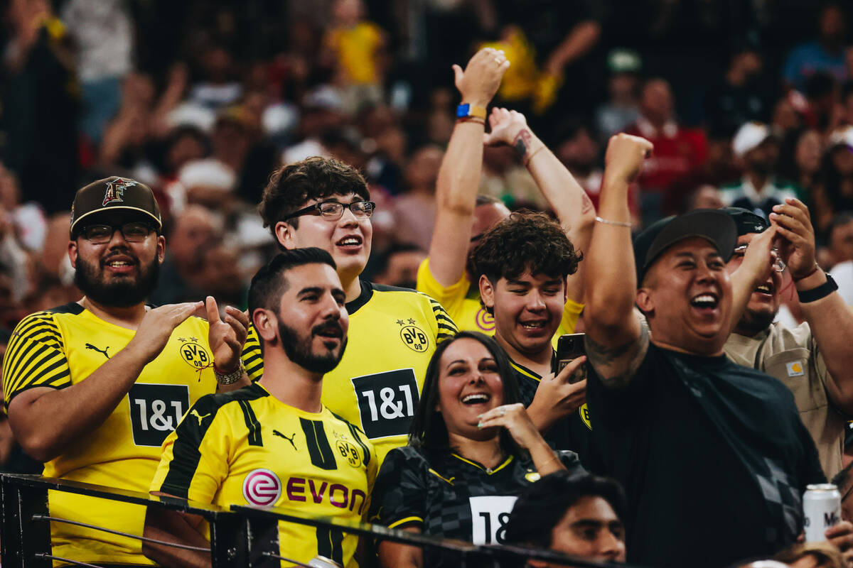 Borussia Dortmund fans cheer as their team scores a goal during a match up against Manchester U ...