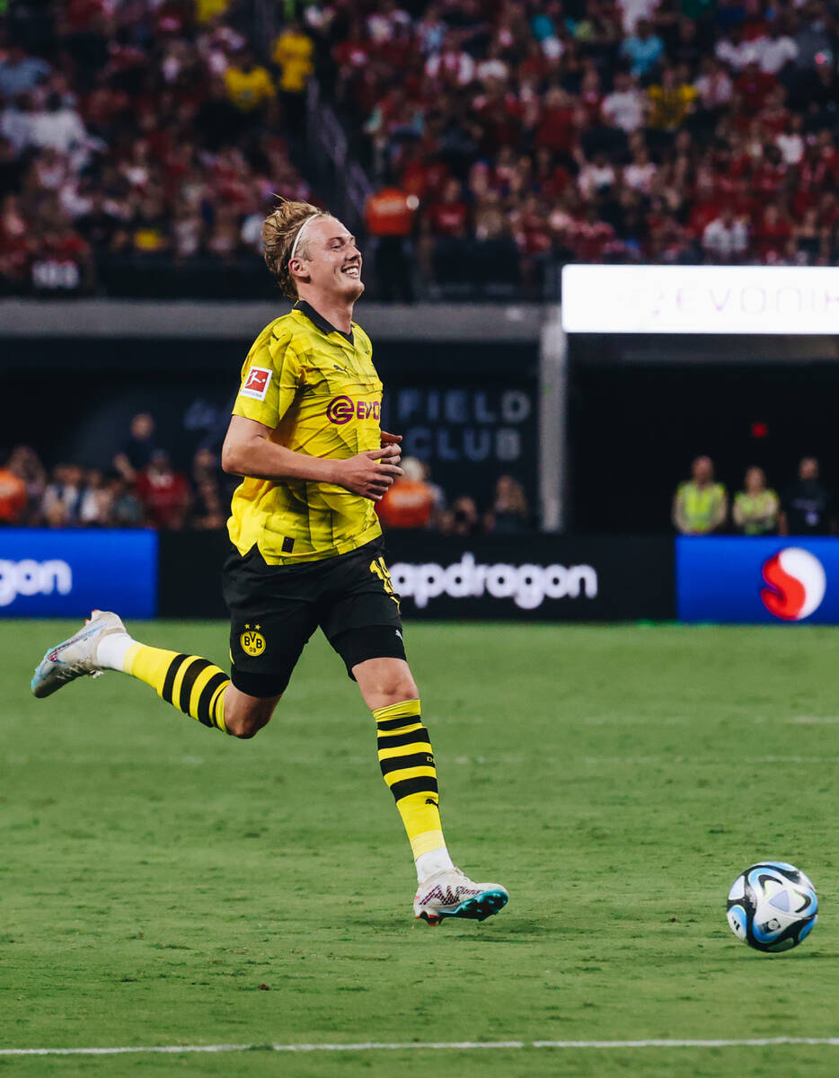Borussia Dortmund midfielder Julian Brandt laughs as he chases the ball during a game against M ...