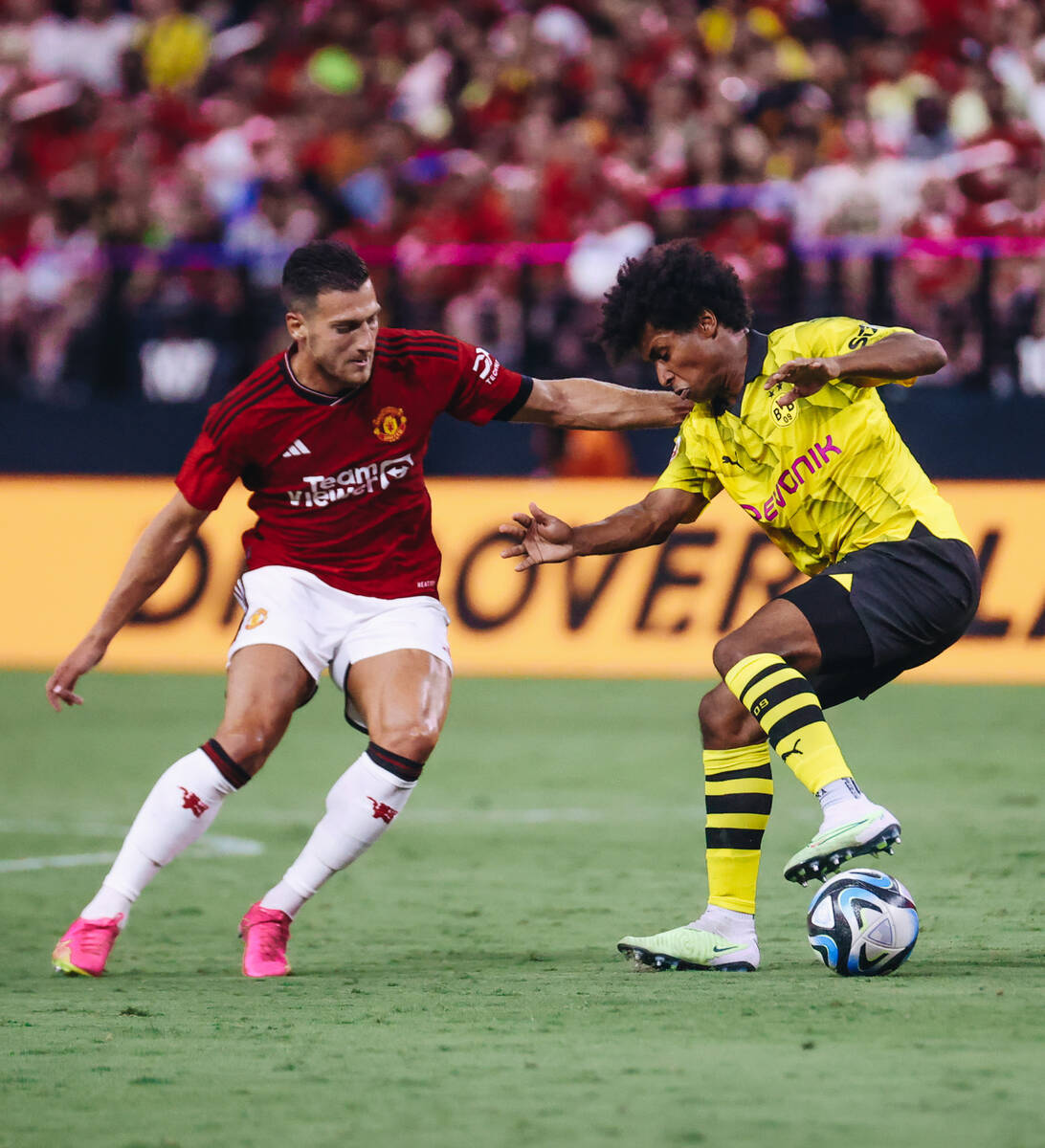 Borussia Dortmund forward Karim Adeyemi (27) fights to keep the ball in his possession during a ...