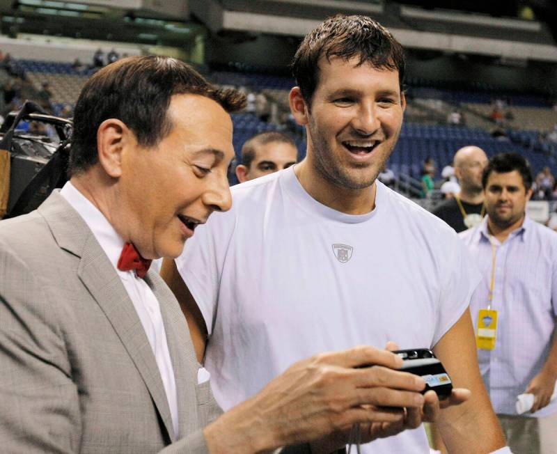 Actor Paul Reubens, left, dressed as character Pee-wee Herman, looks at a photo with Dallas Cow ...