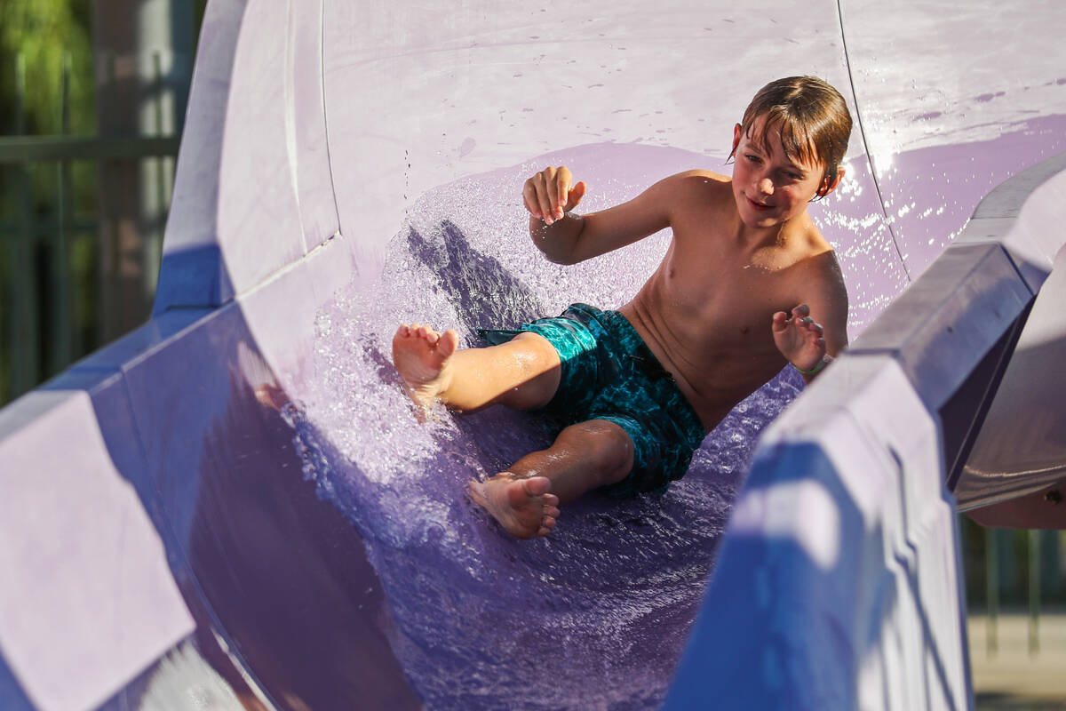 Raiden Taylor, 11, comes flying out of a waterslide at the Splash Back to School Party and Scho ...