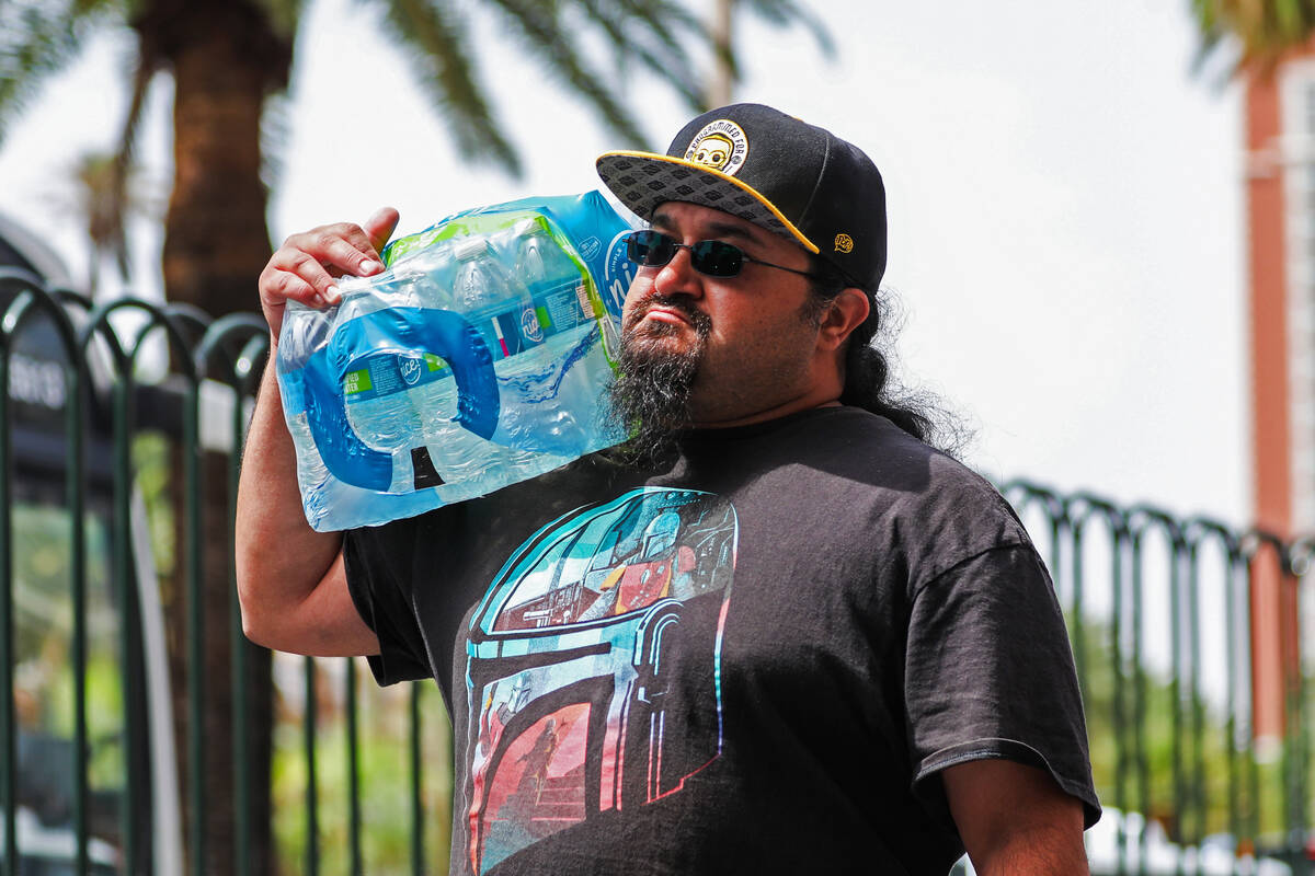 A man carries a whole container of water along the Strip on Monday, July 31, 2023, in Las Vegas ...