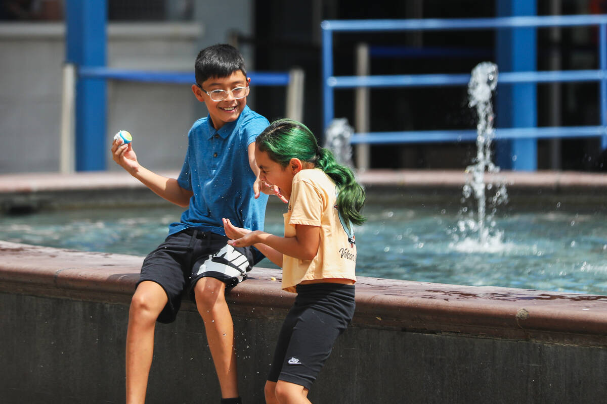 Kids try to keep cool by playing in a fountain along the Strip on Monday, July 31, 2023, in Las ...