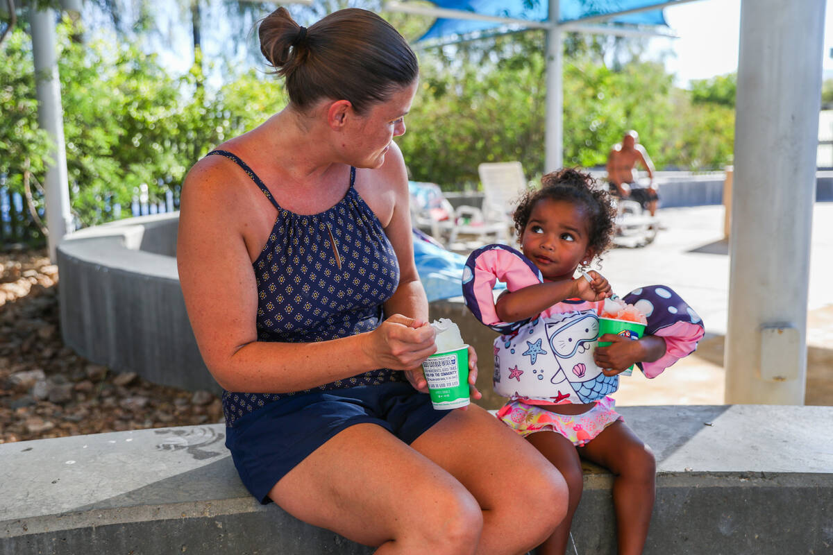 Cynthia Burr and Josie Burr, 2, enjoy some shaved ice while taking a break in the shade at the ...