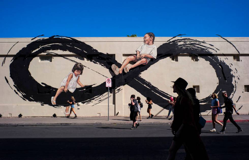 Attendees pass by a mural by Ernest Zacharevic during day 2 of the Life is Beautiful festival i ...