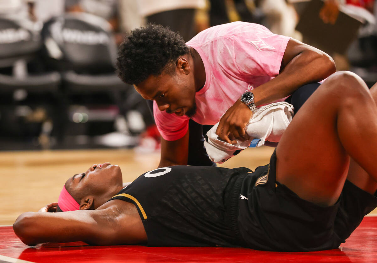 An Aces team physician checks in on Las Vegas Aces guard Jackie Young (0) after she was injured ...