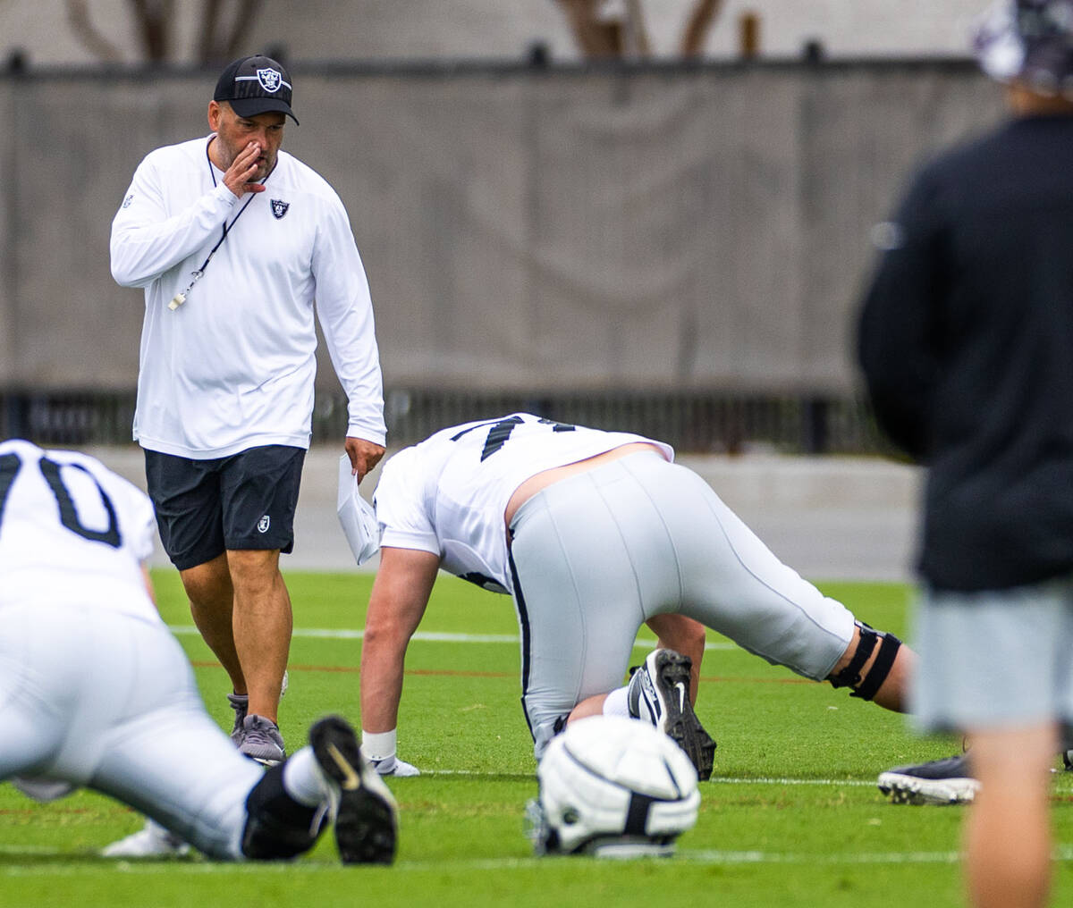 Raiders special teams coach Tom McMahon has some words for guard/tackle Jermaine Eluemunor (72) ...