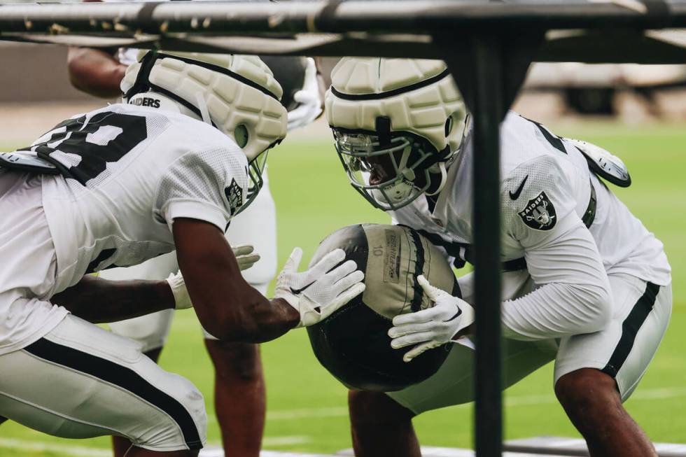 Raiders running back Zamir White (right) runs through a drill with fellow running back Britain ...