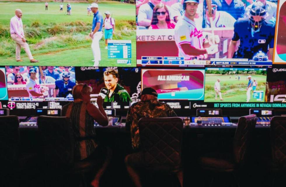 People sit at gambling machines in front of the Circa Sportsbook at Circa Las Vegas on Friday, ...