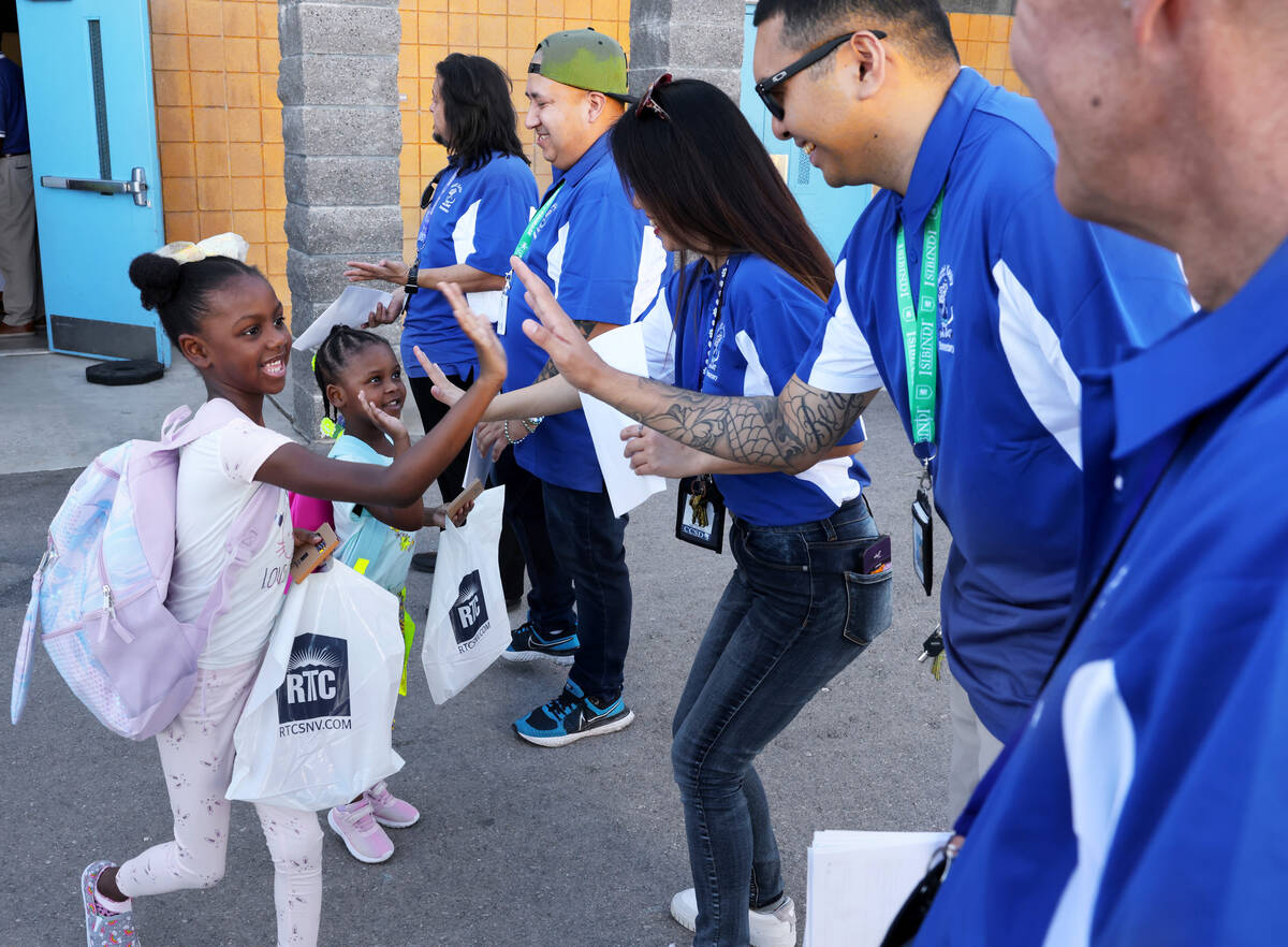 Students Savannah Cooley, 6, and her sister Ava Cooley, 4, greet teachers during the annual &#x ...