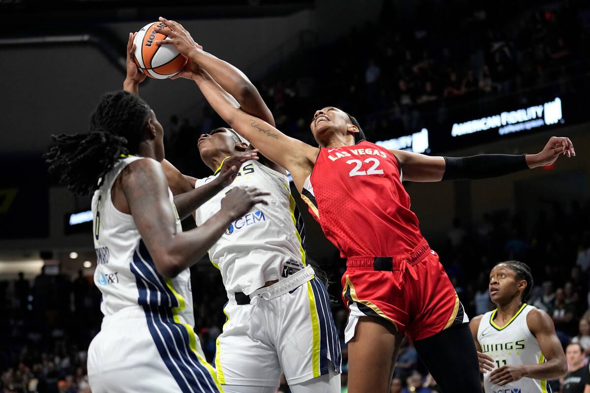 Dallas Wings Teaira McCowan, center, grabs a rebound next to Las Vegas Aces' A'ja Wilson (22) a ...