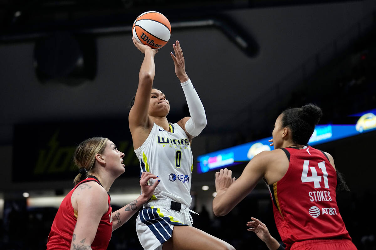 Dallas Wings forward Satou Sabally (0) takes a shot over Las Vegas Aces' Cayla George and Kiah ...