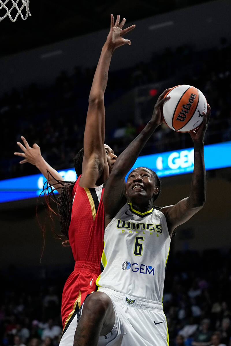 Dallas Wings forward Natasha Howard (6) takes a shot as Las Vegas Aces' Alaina Coates, left, de ...