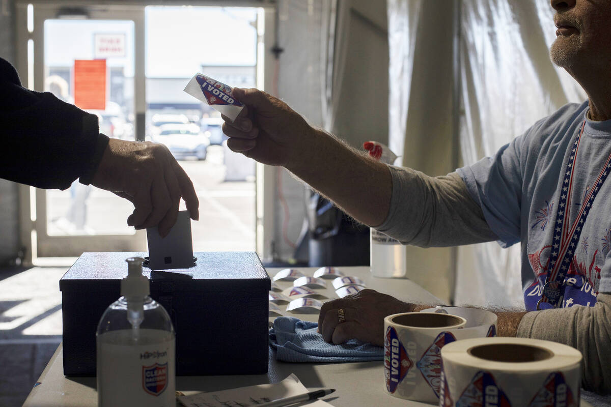 Volunteer Dennis Kepper hands out stickers on the last day of early voting in November 2022 at ...