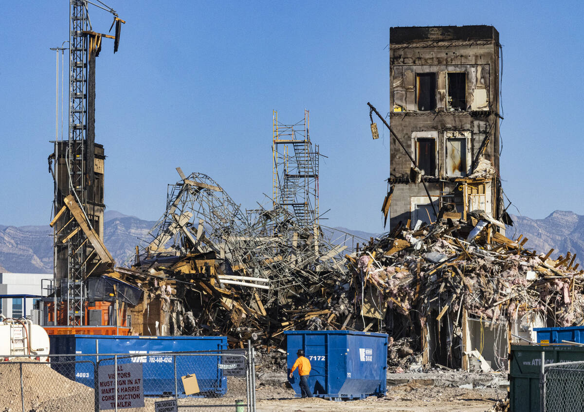 Large piles of debris at the scene where a fire destroyed an apartment complex under constructi ...