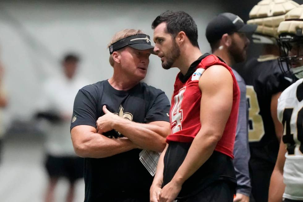 Former NFL head coach Jon Gruden talks with New Orleans Saints quarterback Derek Carr (4) at th ...