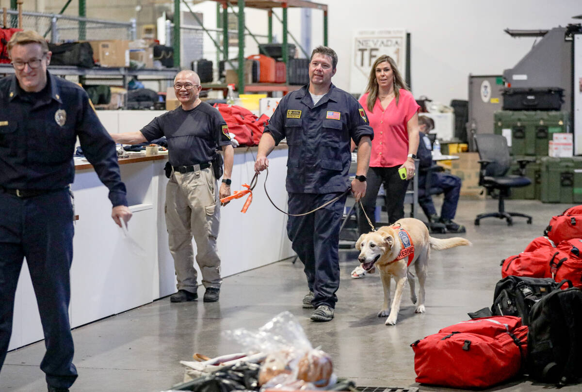 Donovan Kutsenda, search team manager, walks with K-9 Dexter at the Nevada Task Force 1 warehou ...