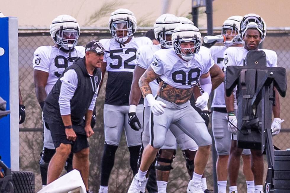 Raiders defensive end Maxx Crosby (98) looks for another after striking a dummy during training ...