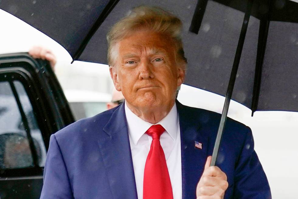 FILE - Former President Donald Trump walks to speak with reporters before boarding his plane at ...