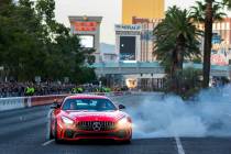 Racer Lewis Hamilton tests the track with doughnuts in a Mercedes before racing down the Strip ...