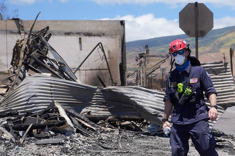 A member of a search-and-rescue team walks along a street, Saturday, Aug. 12, 2023, in Lahaina, ...