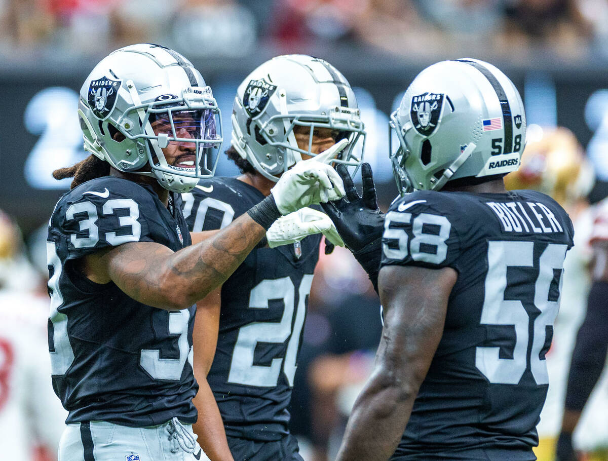 Raiders safety Roderic Teamer (33) celebrates a big stop with linebacker Darien Butler (58) dur ...