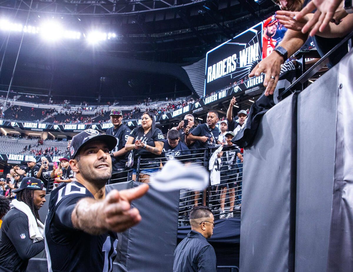 Raiders quarterback Jimmy Garoppolo (10) tosses an arm band to a fan following the first presea ...