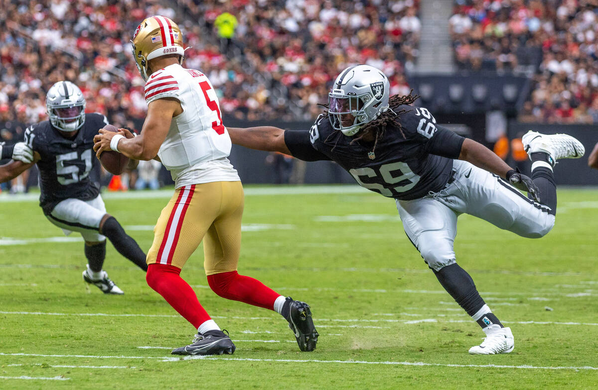 San Francisco 49ers quarterback Trey Lance (5) is closed in on for a sack attempt by Raiders de ...